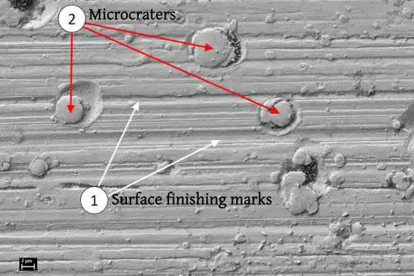 image shows bearing surface damage caused by shaft current, mark 1 is the surface finishing marks, and mark 2 is the microcraters.