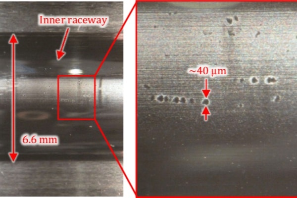 Close-up view of a bearing inner ring showing the frosted, peppered texture caused by early-stage electrical pitting.